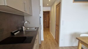 A modern kitchen with a built-in sink, a small countertop, and wooden flooring. - Cozy studio for 4 in L'Alpe d'Huez, near slopes, pets welcome (Huez)