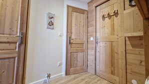 A room with wooden doors, a small picture on the wall, and a light switch. - Cozy studio for 4 in L'Alpe d'Huez, near slopes, pets welcome (Huez)