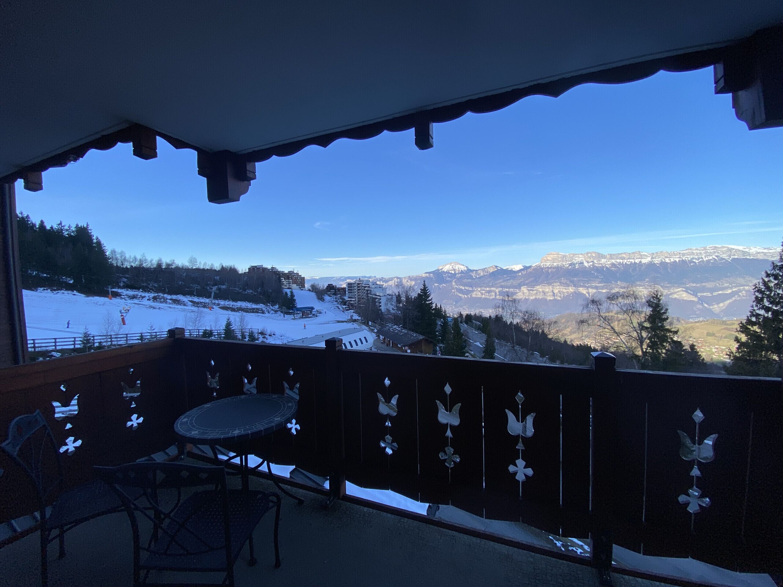 Un balcon offrant une vue sur un paysage enneigé et des montagnes.