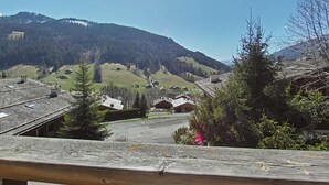Un pueblo rural con casas tradicionales, cielo despejado y montañas al fondo.