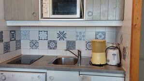 Cocina compacta equipada con microondas, tostadora y lavavajillas.