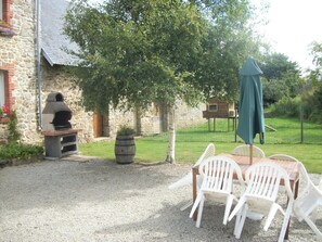 Relax outdoors with a barbecue grill and seating for four under a shaded area.