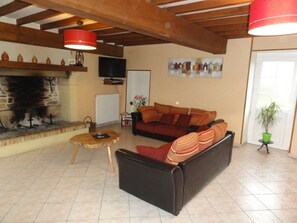 Relax by the fireplace in this inviting living room with a sofa, coffee table, and mounted TV.
