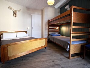 A room with a bunk bed, a single bed, and a wall-mounted deer head decoration.
