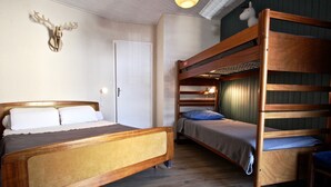 A room with a bunk bed, a single bed, and a wall-mounted deer head decoration.