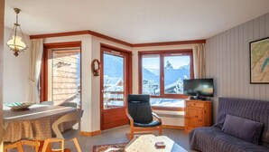 Ein gemütliches Wohnzimmer mit Essbereich, Fernseher und einer Couch.