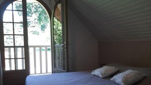 Une chambre à coucher avec un lit, deux oreillers, une fenêtre et une porte.