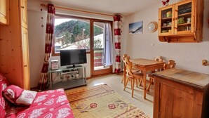A cozy room with a TV, wooden furniture, and a dining area. - STUDIO - APARTMENT -SKI IN SKI OUT -SAINT JEAN D'AULPS SKI RESORT - 4 PEOPLE (Saint-Jean-d´Aulps)
