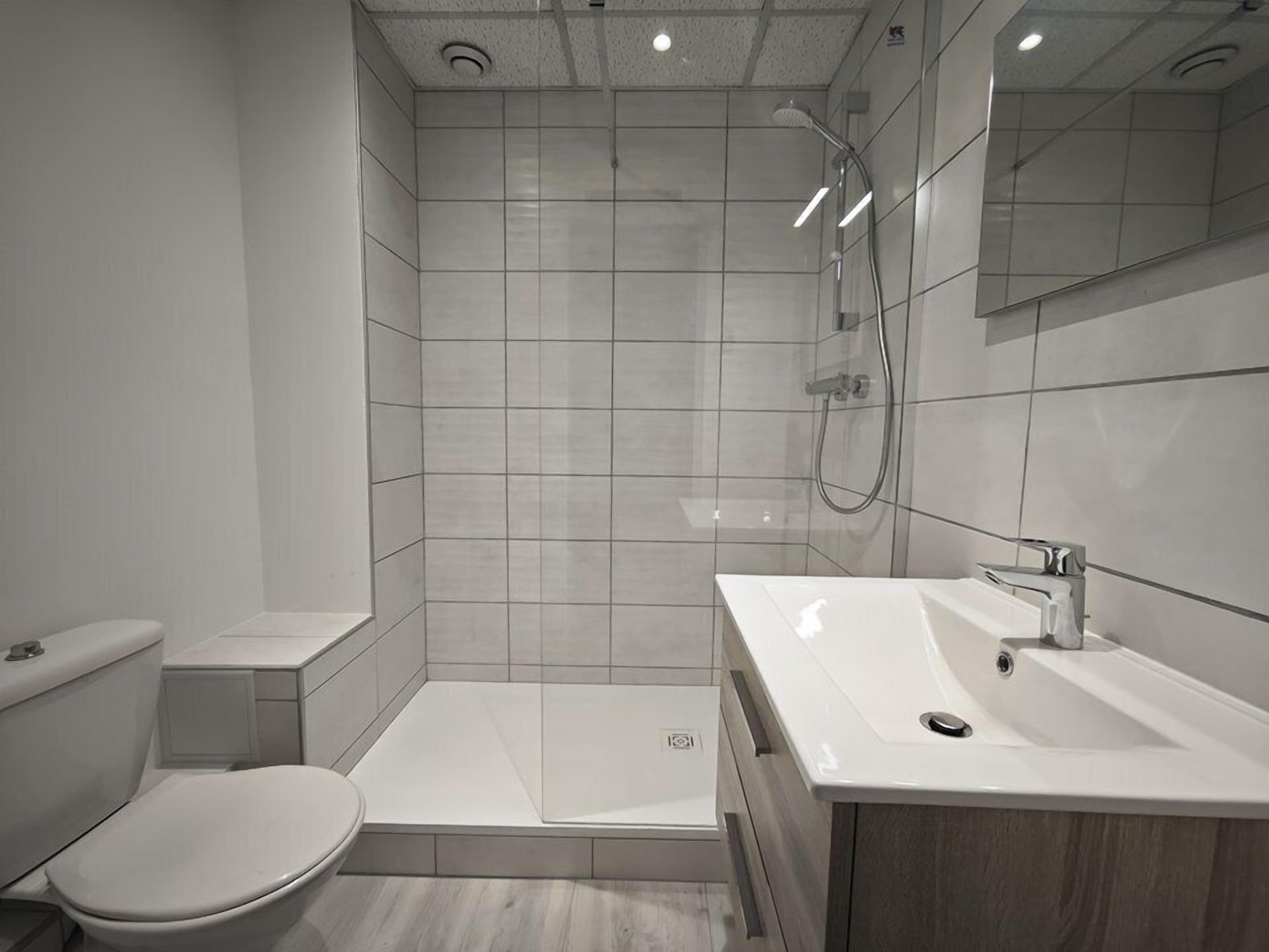 Un baño moderno con ducha, inodoro y lavamanos.