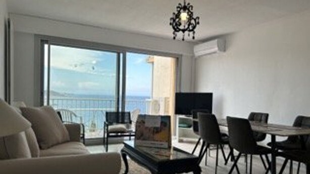 A modern living room with a sofa, dining table, chairs, and a TV. - 6-sleeper apartment in Banyuls-sur-Mer, air conditioning, parking (Banyuls-sur-Mer)