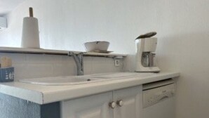 A kitchen with a white countertop, a coffee maker, and a roll of paper towels. - 6-sleeper apartment in Banyuls-sur-Mer, air conditioning, parking (Banyuls-sur-Mer)