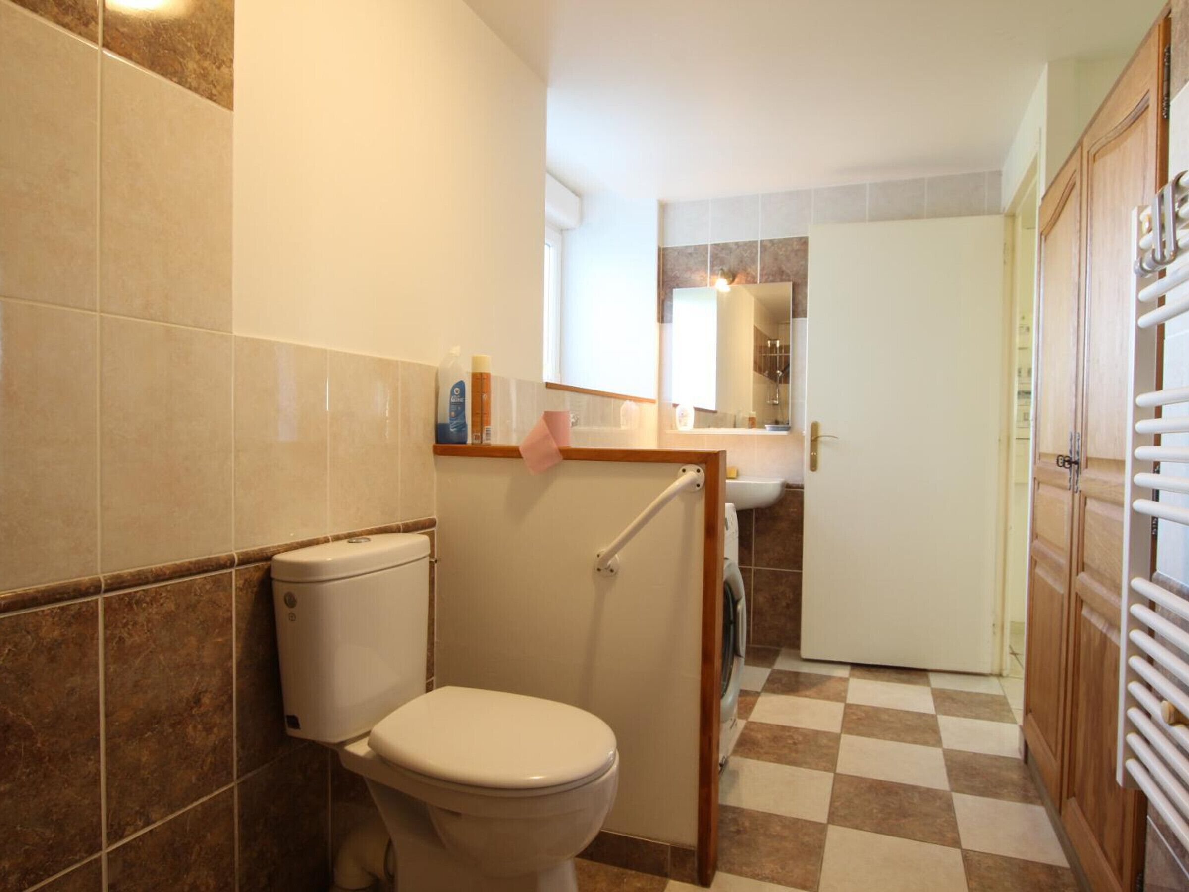 Une salle de bain avec des toilettes, un lavabo et un miroir.