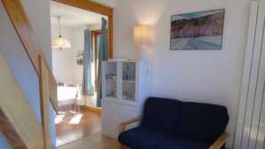 Un soggiorno con un divano blu scuro, un mobile bianco, un tavolino e un quadro appeso al muro.