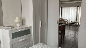Una habitación de hotel con una cama, un armario, un escritorio y una silla.