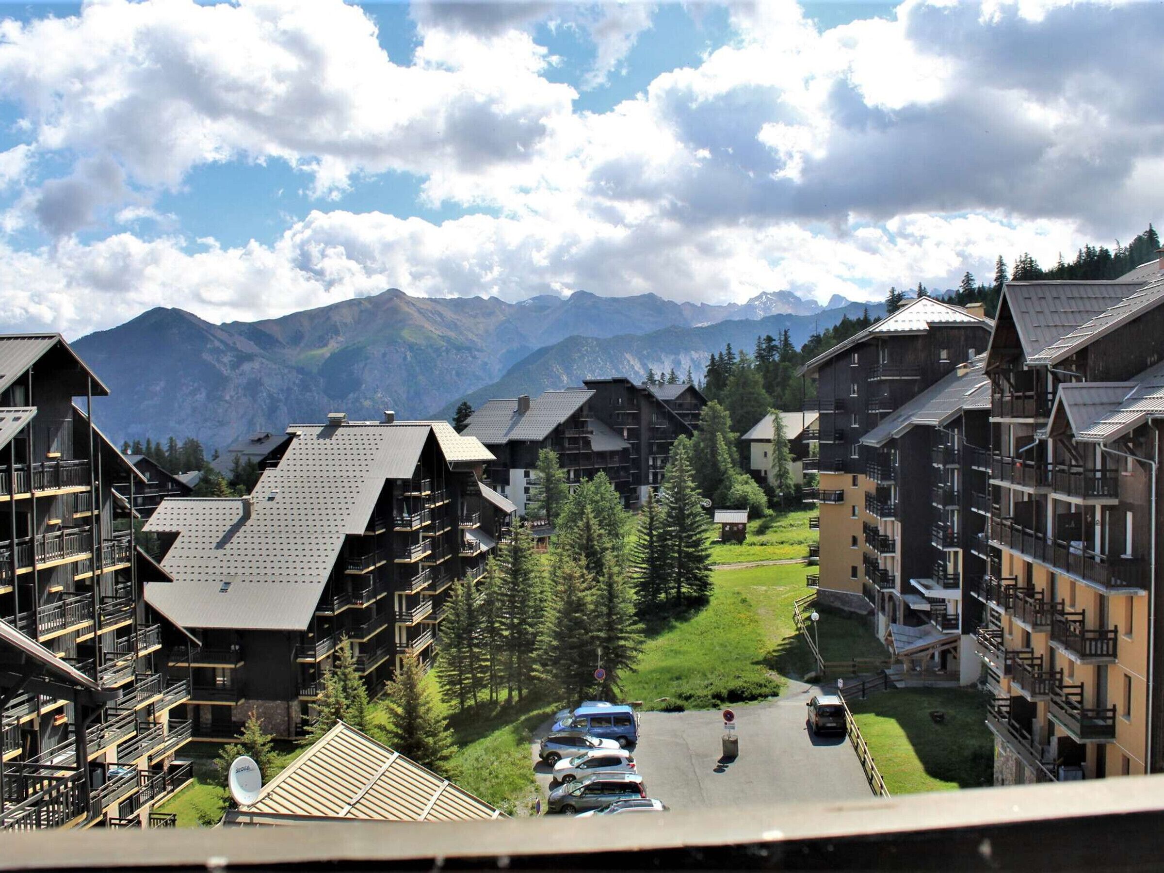 A mountain resort with multi-story buildings, balconies, and a view of the mountains.