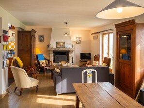 Una sala de estar acogedora con chimenea, asientos y televisor.