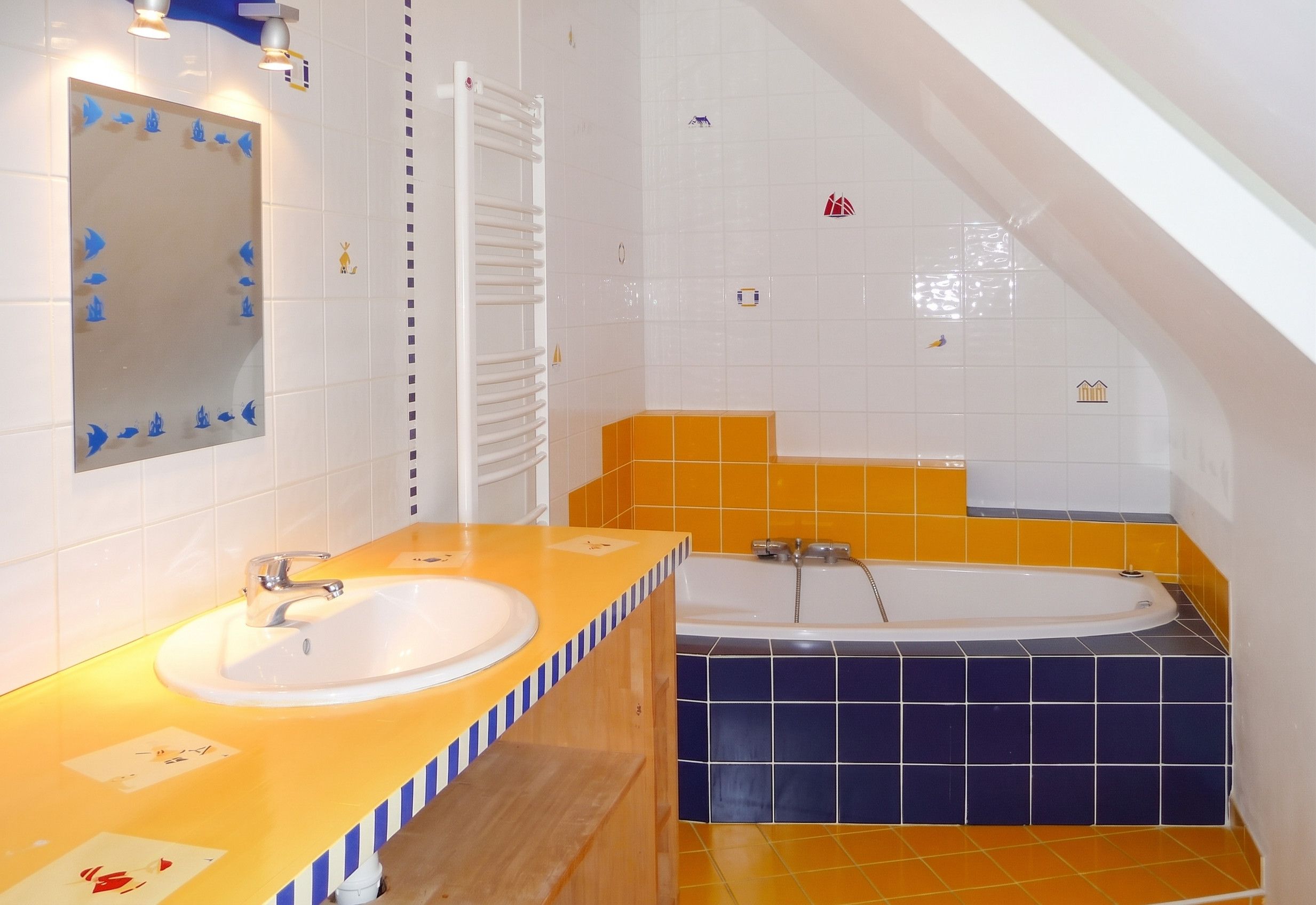 A bathroom with a sink, mirror, towel rack, and bathtub.