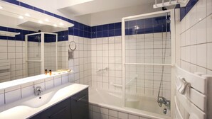 A modern bathroom with a large mirror, a bathtub, and a shower enclosure. - lang 80m2 city center          3br (Colmar)