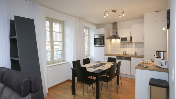 A compact living space with a dining area, kitchenette, and a sofa. - lang 80m2 city center          3br (Colmar)