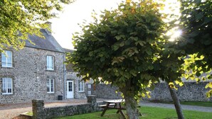 A stone building with a grassy lawn and a picnic table.