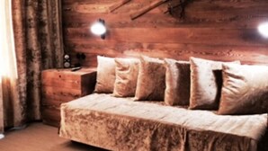 A cozy bedroom with a wooden headboard, a bed with multiple pillows, and a nightstand with a lamp.