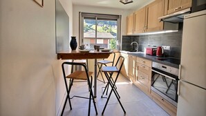 A compact kitchen with a dining area, a window with a view, and modern appliances.