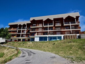A multi-story hotel with balconies and a ski lift visible in the background.