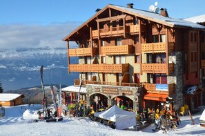 A wooden mountain lodge with a restaurant and lounge area, surrounded by snow and mountains. - D105 - 58 m2 - 3P - 6/8 pers (Prapoutel)