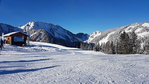 A snow-covered ski slope with a wooden cabin and a mountain backdrop. - STUDIO APARTMENT IN THE HEART OF THE SKI RESORT - SAINT JEAN D'AULPS SKI RESORT -4 PEOPLE - PANORAMIQUE 26 (Saint-Jean-d´Aulps)