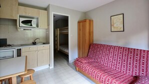 A compact living space with a kitchenette, a sofa, and a bunk bed. - STUDIO APARTMENT IN THE HEART OF THE SKI RESORT - SAINT JEAN D'AULPS SKI RESORT -4 PEOPLE - PANORAMIQUE 26 (Saint-Jean-d´Aulps)