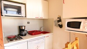 A compact kitchenette with a microwave, coffee maker, and dishwasher. - Cozy 2-Room Apartment for 4 with South-Facing Balcony, Near Ski Lifts and Shops, L'Alpe d'Huez (Huez)