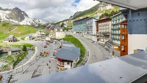 A town with a road curving through it, surrounded by mountains and buildings.