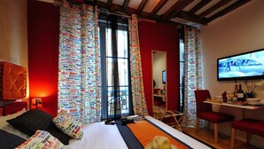 A hotel room with a bed, a TV, a desk, and a chair. - E3GG Travel the world (Paris)