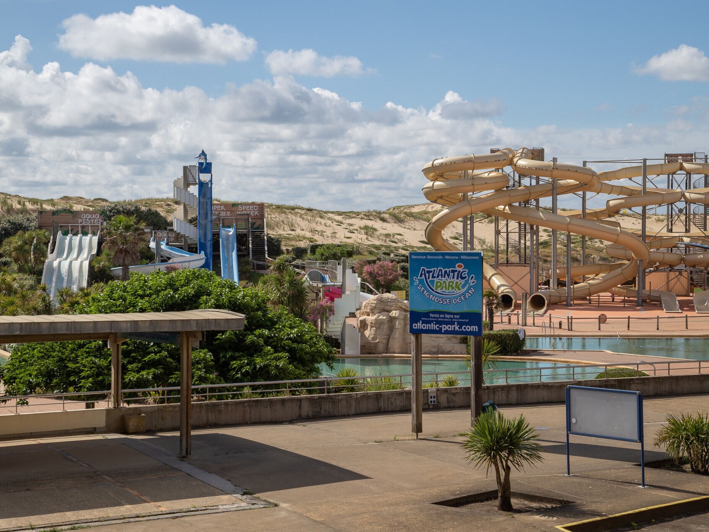 Parque acuático con una gran piscina de olas, un tobogán de velocidad y un cartel de Atlantic Park.