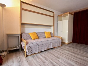 Relax in a stylish room with a sofa, wardrobe, and bedside table.
