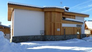 A wooden building with a stone foundation, surrounded by snow.