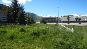 A building with a modern design, surrounded by a grassy area and trees.