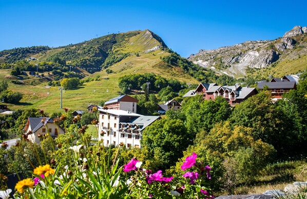 A mountainous landscape with a village, houses with sloped roofs, and a clear sky. - Homerez - Apartment in Saint-Sorlin-d'Arves (Saint-Sorlin-d'Arves)