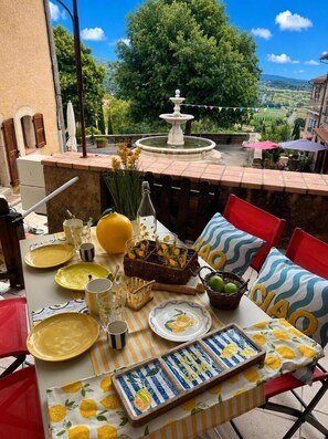 Ein Essbereich im Freien mit einem Tisch für zwei Personen, einer Fontäne und einem schönen Ausblick.