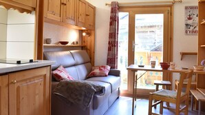 Una cocina acogedora con armarios de madera, un sofá y un comedor con mesa y sillas.