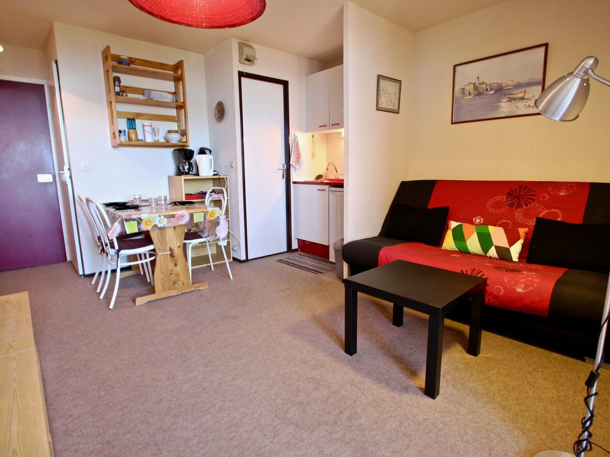 A compact living space with a dining area, a sofa, and a small table.