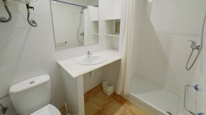 Ein Badezimmer mit Toilette, Waschbecken, Dusche und Spiegel.