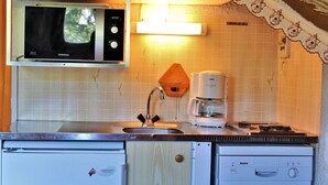 A compact kitchen with a microwave, coffee maker, sink, and a Bosch dishwasher.