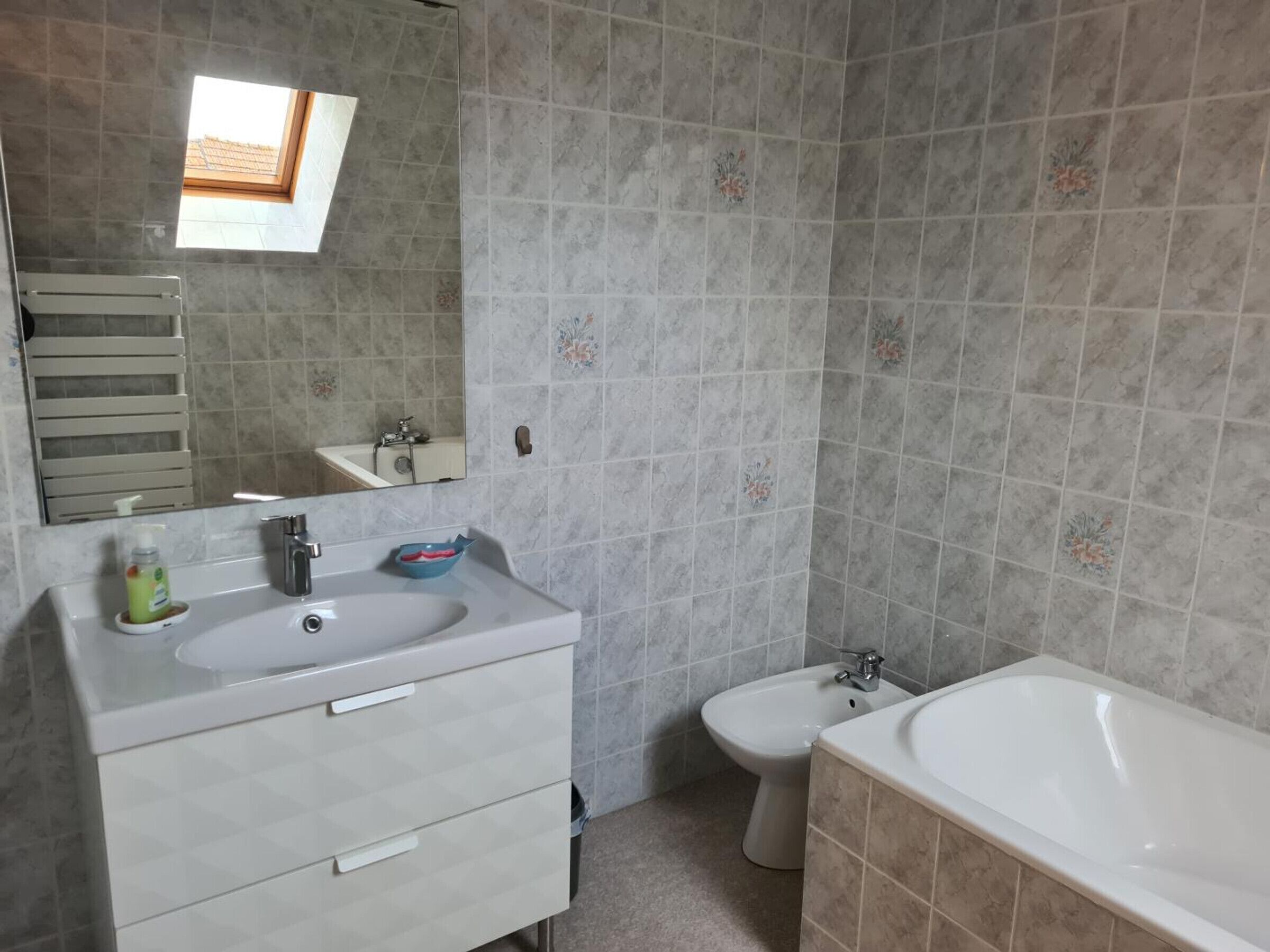 A bathroom with a sink, mirror, toilet, and bathtub.