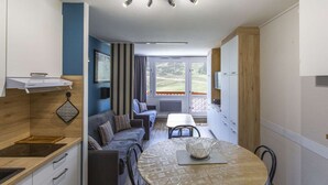 Una cocina compacta con zona de comedor, un sofá y vistas al exterior.