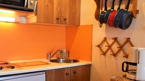 A compact kitchen with a sink, a microwave, and a coffee maker.