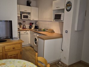 A compact kitchen with a microwave, toaster, and coffee maker.