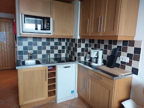 A compact kitchen with a microwave, coffee maker, and dishwasher. - Charming duplex for 4 with stunning views in Arc 1800 (Les Arcs 1800)