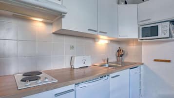 Een koelkast, een magnetron, een kookplaat, een vaatwasser