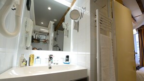 A modern bathroom with a white sink, mirror, and towel rack.